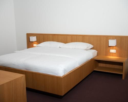 a bed in a room with two night stands and two lamps at Kapellerhof in Stadl-Paura