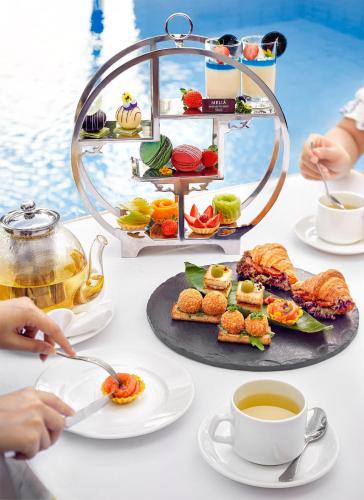 a table topped with plates of food and a cup of tea at Melia Vinpearl Phu Quoc in Phu Quoc