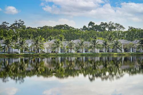 a resort with palm trees in front of a body of water at Melia Vinpearl Phu Quoc in Phu Quoc