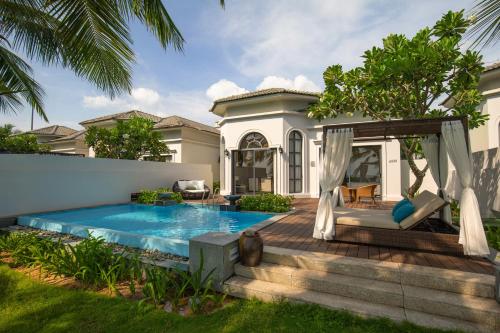 a villa with a swimming pool and a house at Melia Vinpearl Phu Quoc in Phu Quoc