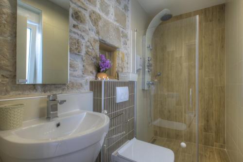 a bathroom with a sink and a shower and a toilet at Waterfront Home - Villa Sailor's Delight in Betina