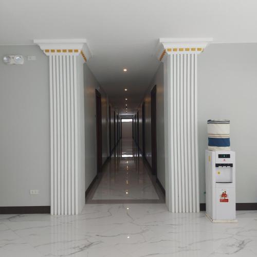 an empty hallway with columns in a building at Hotel NaeR in Romblon