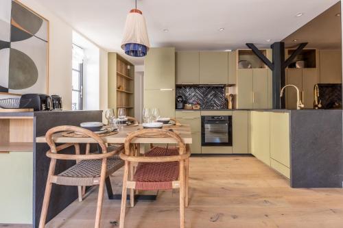 une cuisine avec une table en bois et deux chaises dans l'établissement Arty by PRIM0 C0NCIERGERIE, à Chamalières