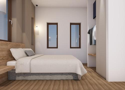 a white bedroom with a bed and two mirrors at Athos Villas in Ouranoupoli