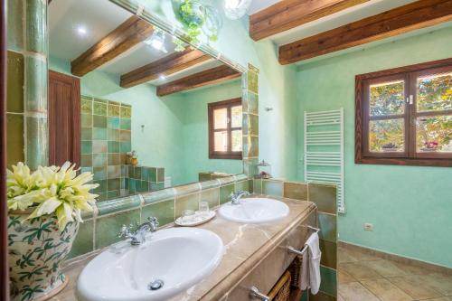 a bathroom with two sinks and a mirror at Son San Marti Gran in Can Picafort