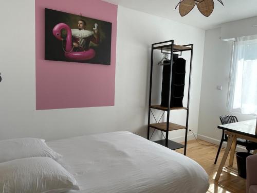 une chambre avec un lit et un mur rose dans l'établissement Banane & C avec sa terrasse, à Lorient