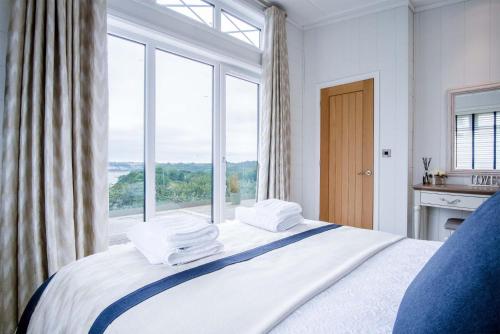ein Schlafzimmer mit einem Bett mit einem großen Fenster in der Unterkunft Shearwater 30 - 2 Bedroom Lodge - Summerhill in Amroth