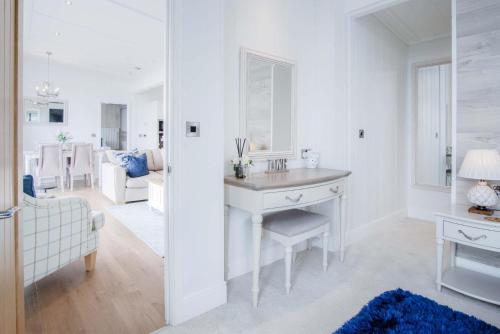 ein weißes Badezimmer mit einem Waschbecken und ein Wohnzimmer in der Unterkunft Shearwater 30 - 2 Bedroom Lodge - Summerhill in Amroth