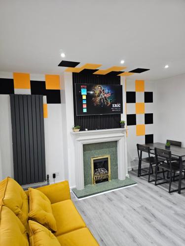a living room with a yellow couch and a fireplace at Bridgepay Modern 4 bedroom House in Cumbria - Whitehaven - Free Parking in Whitehaven