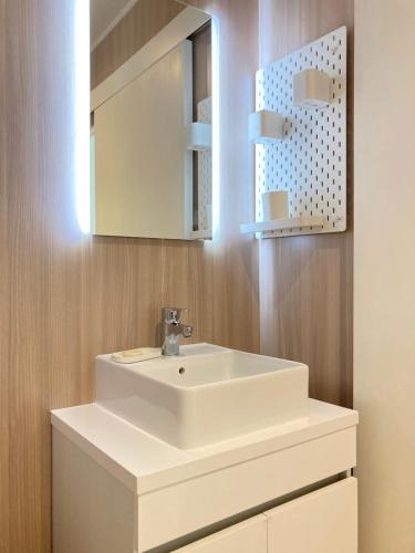 une salle de bain avec un lavabo blanc et un miroir dans l'établissement Tiny House Montpellier avec terrasse, à Montpellier