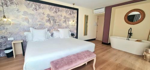 a bedroom with a white bed and a bath tub at Hotel Suites Moma Centro in Villanueva de la Serena