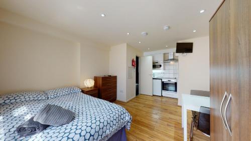 a bedroom with a bed and a desk and a kitchen at Studio29A in London