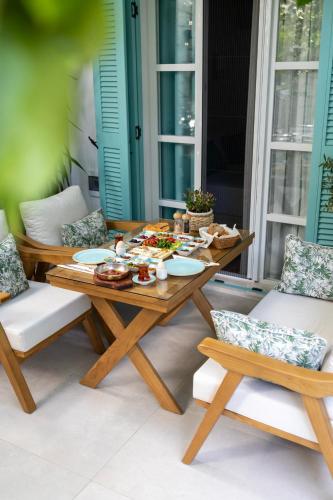 a table and chairs on a patio with food on it at Kairos Hotel in Siğacık