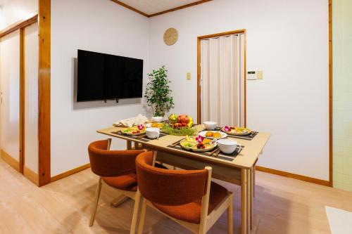 a dining room with a table with food on it at 新規オープン サウナ BBQ ジャグジー付き 最大9名 無料駐車場4台 ビーチまで車で5分 SKY House in Uruma