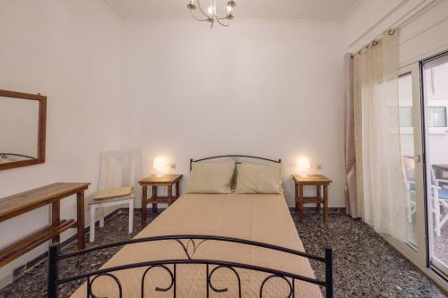 a bedroom with a bed with two tables and a window at Koumbes home in Chania Town