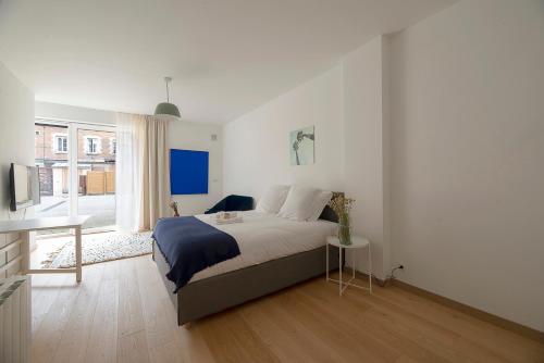 une chambre blanche avec un lit et une table dans l'établissement Le Petit Vasselot, à Rennes