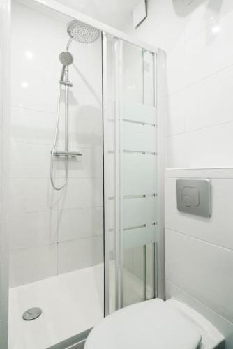 une salle de bain blanche avec douche et toilettes dans l'établissement Blue 1 Bedroom #Montparnasse #Alésia, à Paris