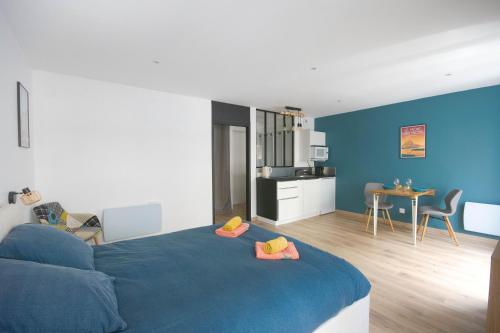 une chambre avec un lit bleu et une cuisine dans l'établissement Kings and Queens - Studio rénové - Notre-Dame, au Havre