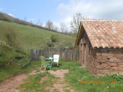 a table and chairs in a yard next to a building at Gîte des Monts in Saint-Izaire