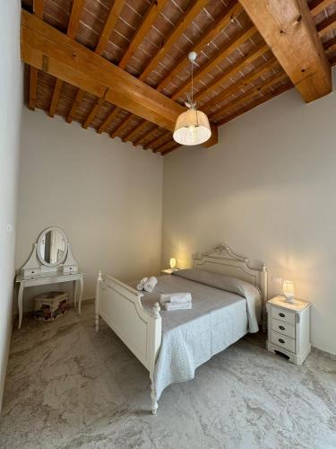 a bedroom with a bed and a vanity and a mirror at Il casone di vada in Vada