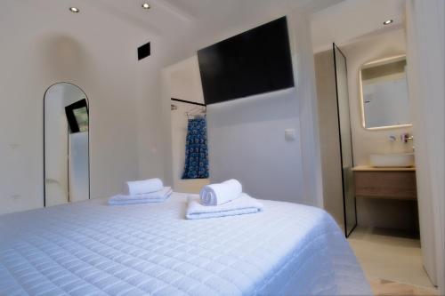 a bedroom with a white bed with towels on it at Villa Mourelo luxury villa in chania with private pool jacuzzi in Chania Town