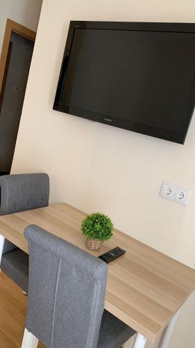 a wooden table with a television on a wall at MCR Barreiro - O Limoeiro in Lavradio