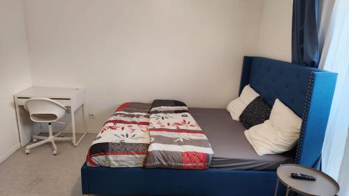 Cette chambre comprend un lit bleu et un bureau. dans l'établissement Chambre meublée cuisine à 20 minutes de Disneyland, à Champs-sur-Marne
