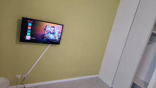 a flat screen tv hanging on a wall at Chambre meublée cuisine à 20 minutes de Disneyland in Champs-Sur-Marne