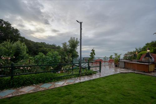 a patio with a view of a yard with grass at De Rock Jungle Living Resort in Coonoor