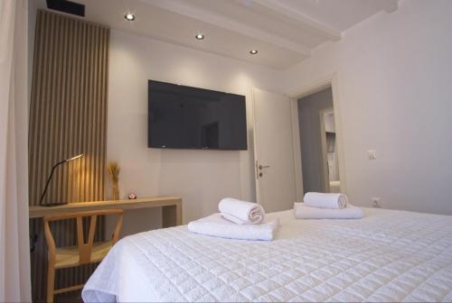 a bedroom with a bed and a tv on the wall at Villa Mourelo luxury villa in chania with private pool jacuzzi in Chania Town