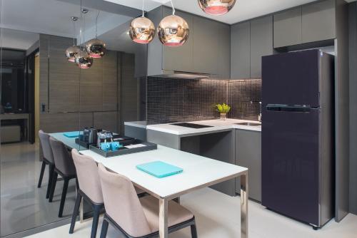a kitchen with a table and chairs and a refrigerator at Seaphere Pattaya Hotel by Elite Suites in Na Jomtien