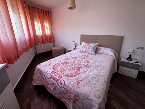 a bedroom with a bed with a pink and white blanket at Casa Vila in Riópar