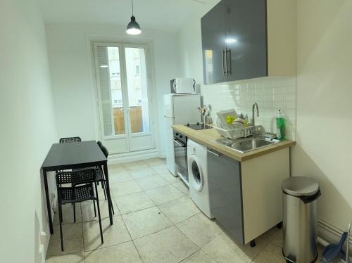une cuisine avec un évier et une machine à laver dans l'établissement Appartement haussmanien, à Paris