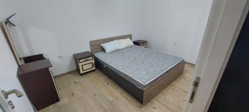 a small bedroom with a bed and a night stand at Апартамент 4-6 човека in Sveti Vlas