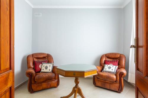 two chairs and a table in a room at Casas De Les Roses in Orba