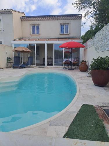 une grande piscine bleue devant une maison dans l'établissement Jolie petite maison tout proche d avignon, à Vedène