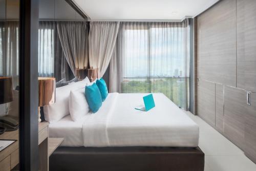 a bedroom with a bed with a laptop on it at Seaphere Pattaya Hotel by Elite Suites in Na Jomtien
