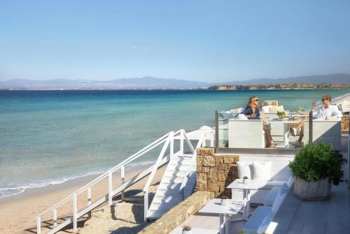 two people sitting at a table near the beach at Sani Beach in Sani Beach