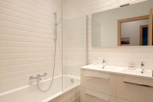 une salle de bain blanche avec un lavabo et une douche dans l'établissement Le Charmant Vasselot, à Rennes