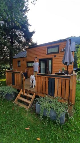a man and a dog standing in front of a tiny house at Tiny House Waldschmied 1 in Latzendorf