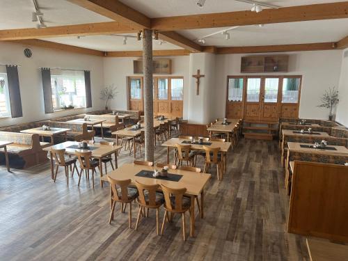 a restaurant with tables and chairs and a cross on the wall at Gasthaus & Metzgerei Besenhardt in Wackersdorf
