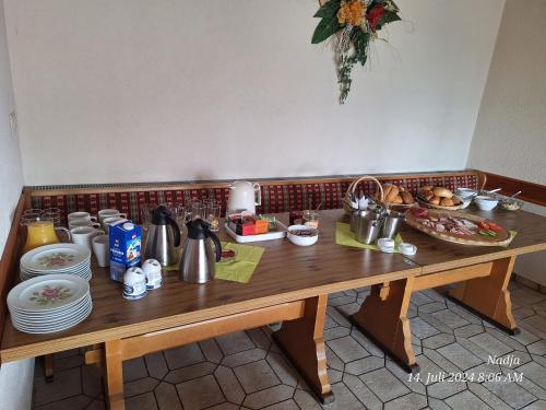a wooden table with plates and utensils on it at Gasthaus & Metzgerei Besenhardt in Wackersdorf