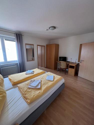 a large bedroom with two beds and a desk at Gasthaus & Metzgerei Besenhardt in Wackersdorf