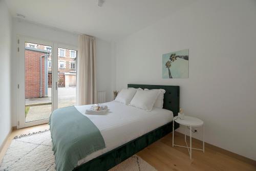 une chambre avec un grand lit et une fenêtre dans l'établissement Le Charmant Vasselot, à Rennes