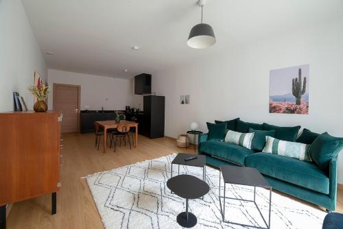 un salon avec un canapé vert et une table dans l'établissement Le Charmant Vasselot, à Rennes