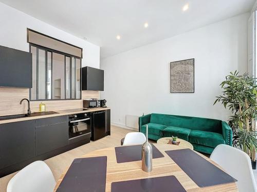 - un salon avec une table et un canapé vert dans l'établissement Cosy appartement, Lyon Centre Capucins 1, à Lyon