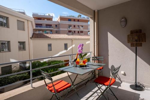 a balcony with a table and chairs on a balcony at Le Cocon de la Pinède - Antibes proche plage in Antibes