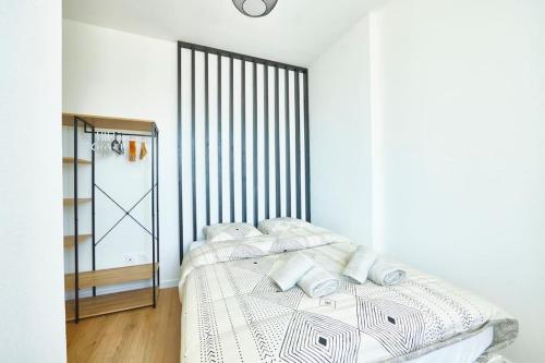 une chambre blanche avec un lit et un miroir dans l'établissement BM-2 Appartement entier F2 au 2ème étage -1 à 4 pers, à Mulhouse