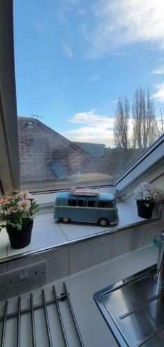 a blue bus sitting on a window sill with plants at Studio29A in London