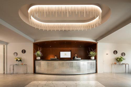 a lobby with a reception desk and a large chandelier at Hotel American Palace Eur in Rome